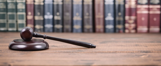 A gavel in front of law books